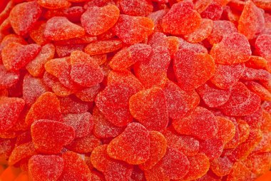 Kırmızı ve turuncu şekerlerin dokusu. Tatlılar yığının üzerinde. Şekerci dükkanı penceresi.