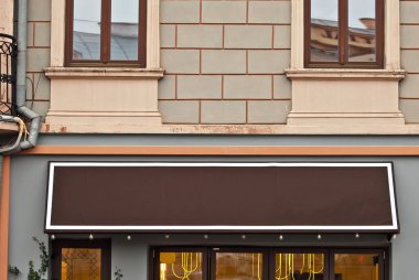 Binada dikdörtgen şeklinde işaret var. Boşluk ve boşluğu metin için kopyala. Tasarım için maket. Reklam için boş bir şablon. Evin ön cephesinde beyaz bir çerçeve. Mimarlık üzerine reklam..