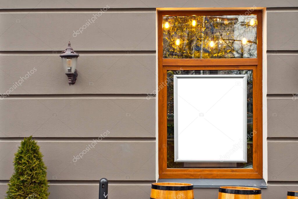 Rectangular sign on the building. Copy space and space for text. Mockup for design. Blank template for advertising. White frame on a glass case. Advertising on the window of a restaurant or shop.