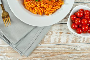 Beyaz tabakta et ve domatesli makarna. Sehpanın üzerinde makarna. Yemek yakınındaki metin için boşluk ve boş alanı kopyala.