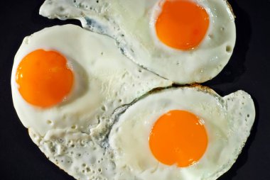 Siyah tabakta çırpılmış yumurta. Eski bir beton masada kızarmış yumurta.. 