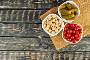 Beyaz kasede marine edilmiş domates, salatalık ve mantar. Siyah arka planda turşulu sebzeler. Sehpada yemek. Yemek yakınındaki metin için boşluk ve boş alanı kopyala.