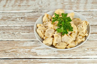 Eski püskü bir masada beyaz bir tabakta hamur tatlısı. Sarı hamurlu hamur köfteleri yakından. Beyaz tahta arka planda yemek. Tabağa yakın metin için boşluk ve boşluk kopyala.