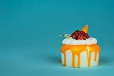 Mavi arka planda sarı kremalı bir parça beyaz pasta. Kek, kivi ve meyveli yakın plan..