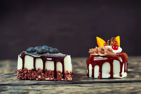 两块白色的蛋糕 背景是黑色的巧克力奶油 用蓝莓和水果在木制桌子上做的蛋糕 — 图库照片