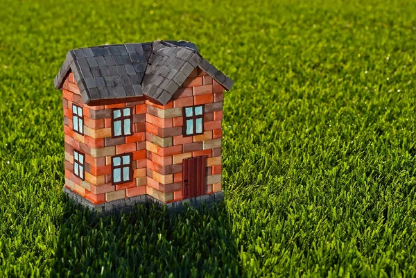 Een Stenen Speelgoedhuis Het Gras Oranje Huis Een Groene Weide — Stockfoto