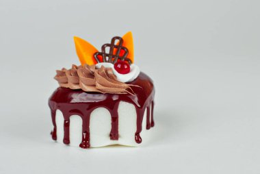 Beyaz arka planda çikolata kremalı bir parça beyaz pasta. Meyveli kek yakın plan..