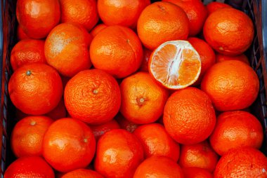 Kutuda bir sürü turuncu mandalina var. Yuvarlak mandalina dokusu yakın. Markette ve süpermarkette meyve satışı.