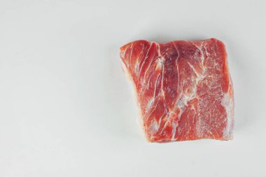 Kırmızı et yaklaş. Beyaz arka planda izole edilmiş bir domuz parçası. Et yemekleri için hazırlık. Yemek yakınındaki metin için boşluk ve boş alanı kopyala.