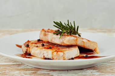 Kızarmış et parçaları. Biberiyeli biftek ve beyaz tabakta biber. Et tabağını kapat..