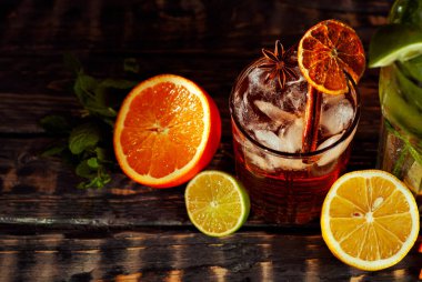 Siyah arka planda pipetli, buzlu ve meyveli kokteyller. Eski ahşap bir masada alkollü içecekler. Yakın plan. Sefil kahverengi bir tahtanın üzerinde iç..