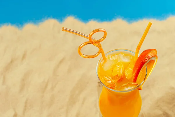 ビーチでオレンジカクテル 氷とアルコール飲料 砂の上にオレンジを閉じる — ストック写真