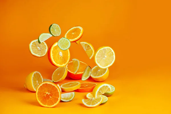 Orangen Zitronen Und Limetten Scheiben Schneiden Zitrusgemüse Fliegt Auf Orangefarbenem Stockbild