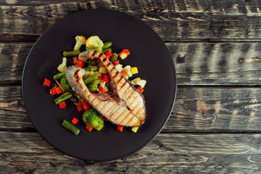 Izgara somon bifteği. Limonlu ve sebzeli kırmızı somon. Haşlanmış lahana, havuç, bezelye ve brokoli salatası. Yemek yakınındaki metin için boşluk ve boş alanı kopyala.