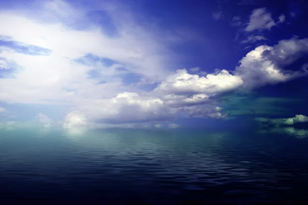 Cielo azul nublado que sale hacia el horizonte sobre una superficie azul del mar — Foto de Stock