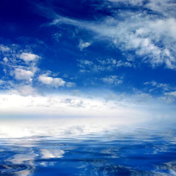 Cielo azzurro nuvoloso che parte per orizzonte sopra una superficie azzurra del mare — Foto Stock