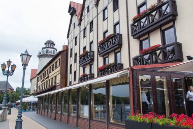 Kaliningrad, Russia - August 01 2019: the view of old building facade in a fisherman village and lighthouse on background on August 01 2019 in Kaliningrad, Russia.