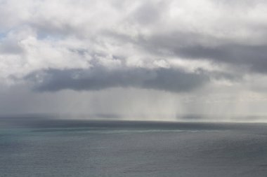 Okyanusun üzerindeki ufuktaki yoğun yağmurlu bulutların manzarası, Yeni Zelanda.