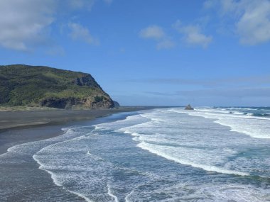 Karekare sahilinin hava manzaralı dalgaları ve küçük kayalık bir çıkıntısı, Batı Sahili Sahili, Auckland, Yeni Zelanda.
