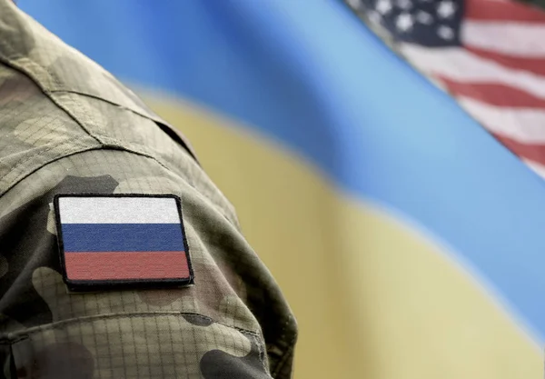 Flag of Russia on military uniform and flags of the Ukraine and USA at background. Russia VS Ukraine.