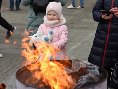 Lviv, Ukrayna - 6 Mart 2022: Mülteciler Ukrayna 'nın batısındaki Lviv tren istasyonunun dışında bir şenlik ateşi etrafında ısınıyorlar.