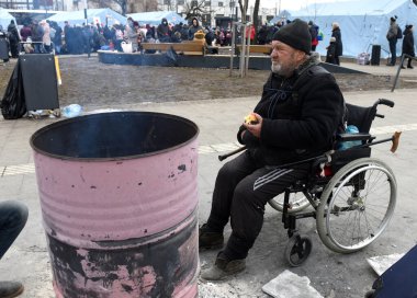 Lviv, Ukrayna - 6 Mart 2022: Mülteciler Ukrayna 'nın batısındaki Lviv tren istasyonunun dışında bir şenlik ateşi etrafında ısınıyorlar.