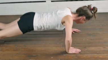 Spor yapan atletik kadın içeride spor yapıyor.