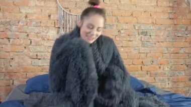 Yatakta dans eden mutlu kadın