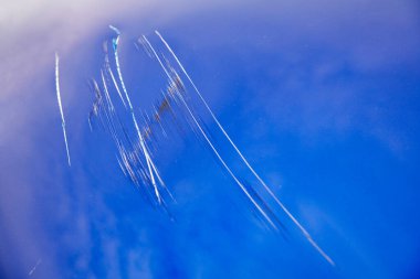 Mavi bir arabada büyük çizikler var. Araç vandallar tarafından hasar görmüş. Yakın çekim..