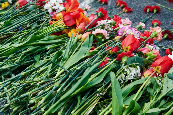 Ett Gäng Olika Blommor Granitmonumentet Tulpaner Och Nejlikor Victory Day — Stockfoto