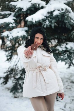 Kışın Noel ağacının yanında elinde çikolata parçasıyla güzel bir genç kızın portresi.. 