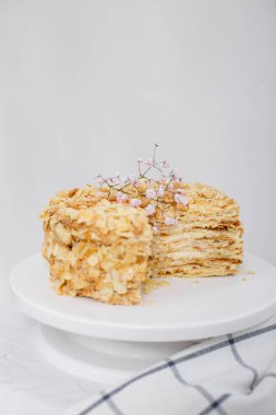 Beyaz arka planda izole edilmiş beyaz tepside kesilmiş Napolyon pastası. Ekşi kremalı puf böreği. Boşluğu kopyala. 