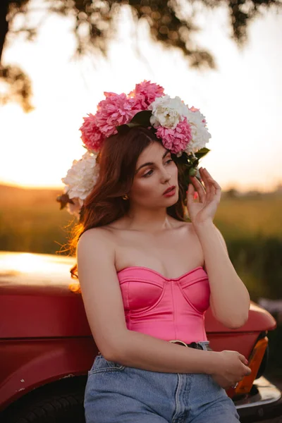 Красивая Молодая Женщина Длинными Волнистыми Волосами Розовом Корсете Позирует Пионами — стоковое фото