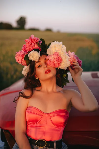 Красивая Молодая Женщина Длинными Волнистыми Волосами Розовом Корсете Позирует Пионами — стоковое фото