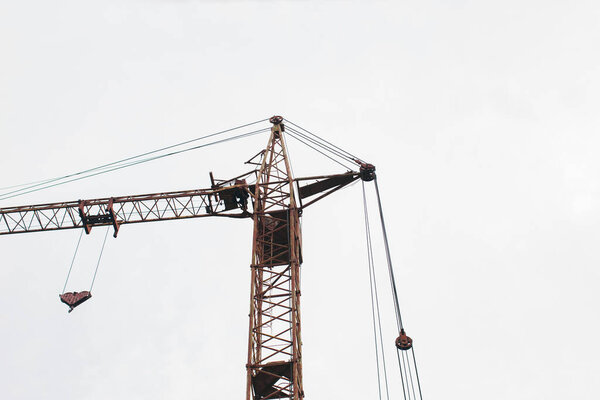 Construction crane on a white sky background. Bottom view.