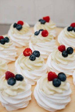 Tahta üzerinde ahududu ve yaban mersinli tatlı. Meyveli tatlı pavlova. 