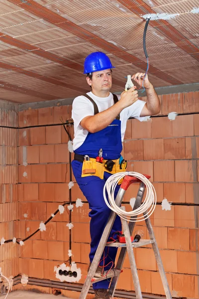 Elettricista che lavora sui fili del soffitto — Foto Stock