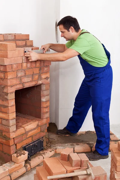Worker building brick stove or fireplace — Stock Photo, Image