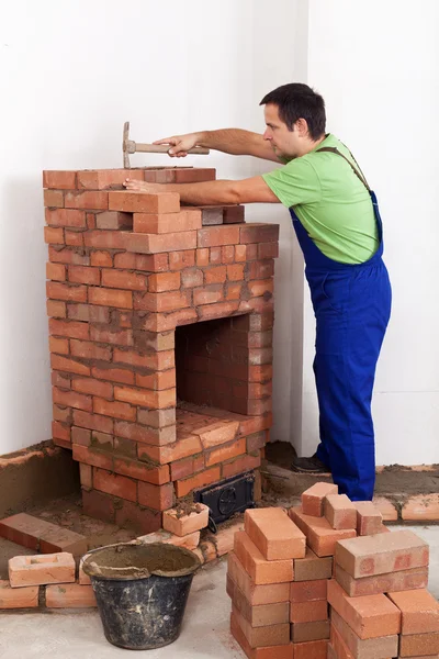 Worker building a brick stove — Stock Photo, Image