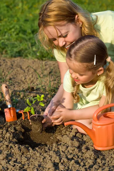 Vrouw en meisje in de tuin — Stockfoto