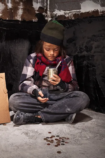 Poor beggar child boy reviews the money he received — Stock Photo, Image