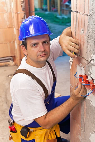 Eletricista instalando fios em um novo edifício — Fotografia de Stock