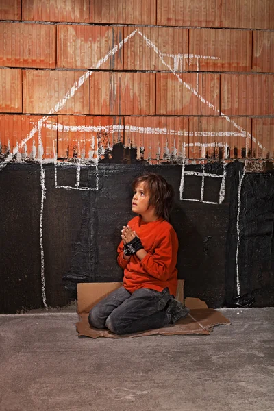 Poor homeless beggar boy praying for a shelter concept — Stock Photo, Image