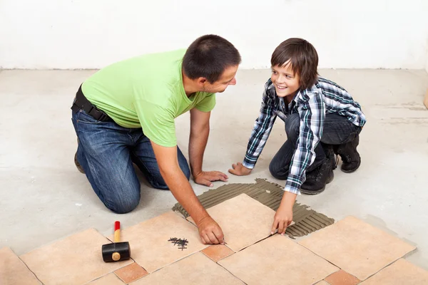 父と息子の陶磁器の床タイルを敷設 — ストック写真