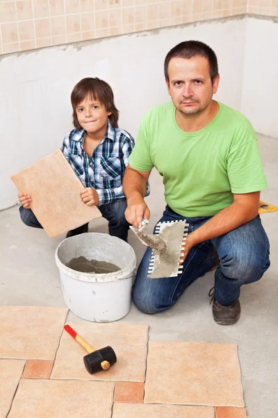 Padre e figlio posa piastrelle del pavimento insieme — Foto Stock