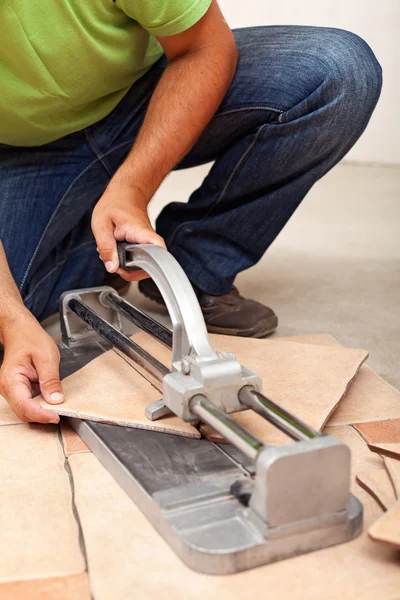 Worker cutting ceramic floor tiles — Stock Photo, Image