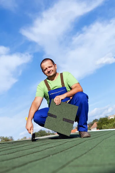 Worker installs bitumen roof shingles — Stock Photo, Image
