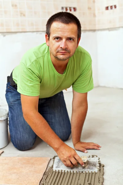 Worker installing ceramic floor tiles — Stock Photo, Image