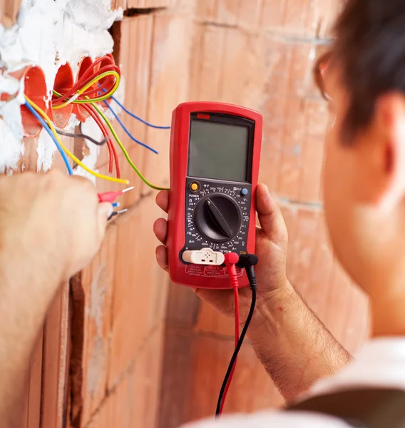 Elektriker händer med multimeter - närbild — Stockfoto