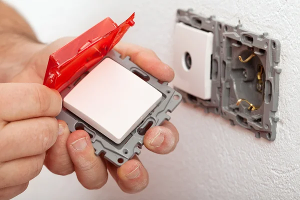 Electrician hand changing or installing an electrical switch — Stock Photo, Image